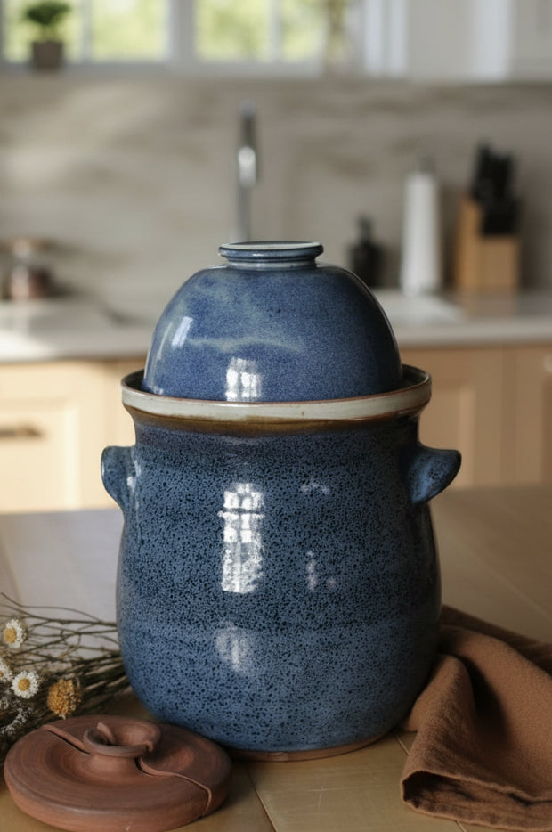 Blue ceramic crock with a lid on a wooden surface